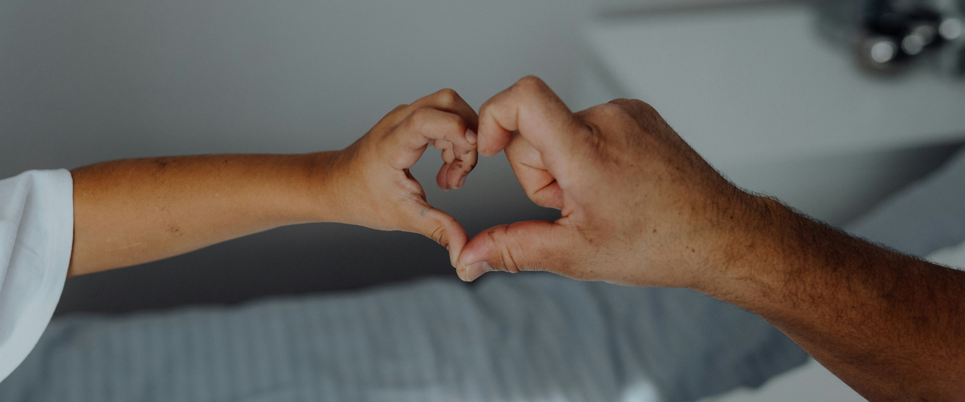 Two hands forming a heart shape, representing care and support.