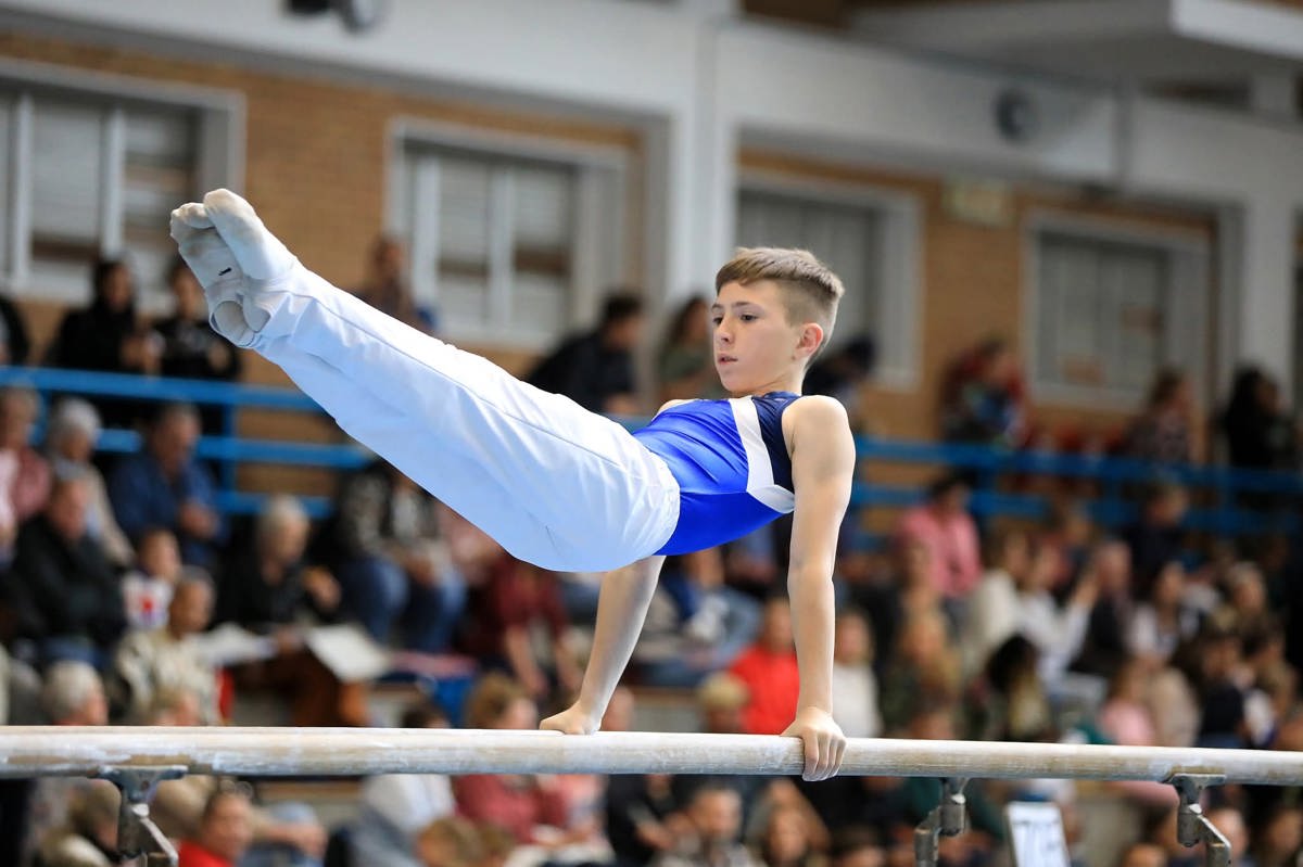 Thirteen-year-old gymnast Xavier Snyman performing a controlled handstand in a training gym.