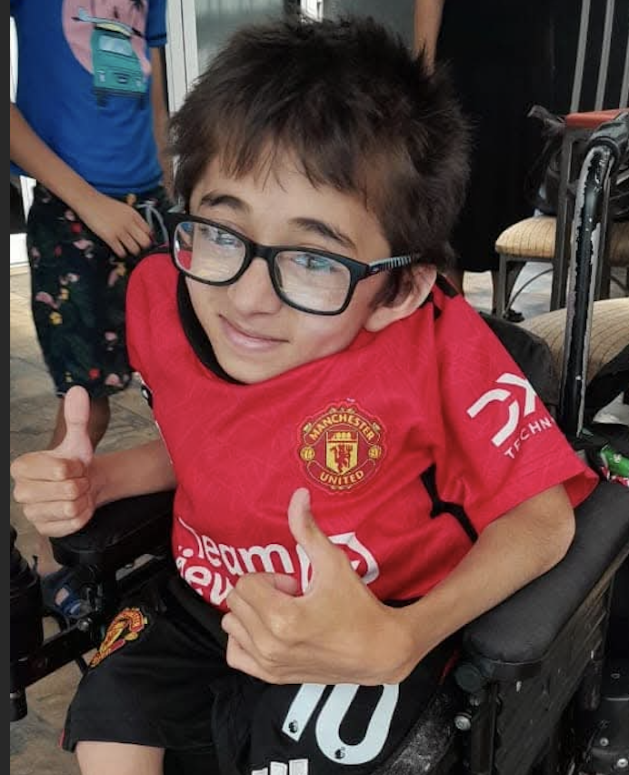 Liam January using his motorised wheelchair at school