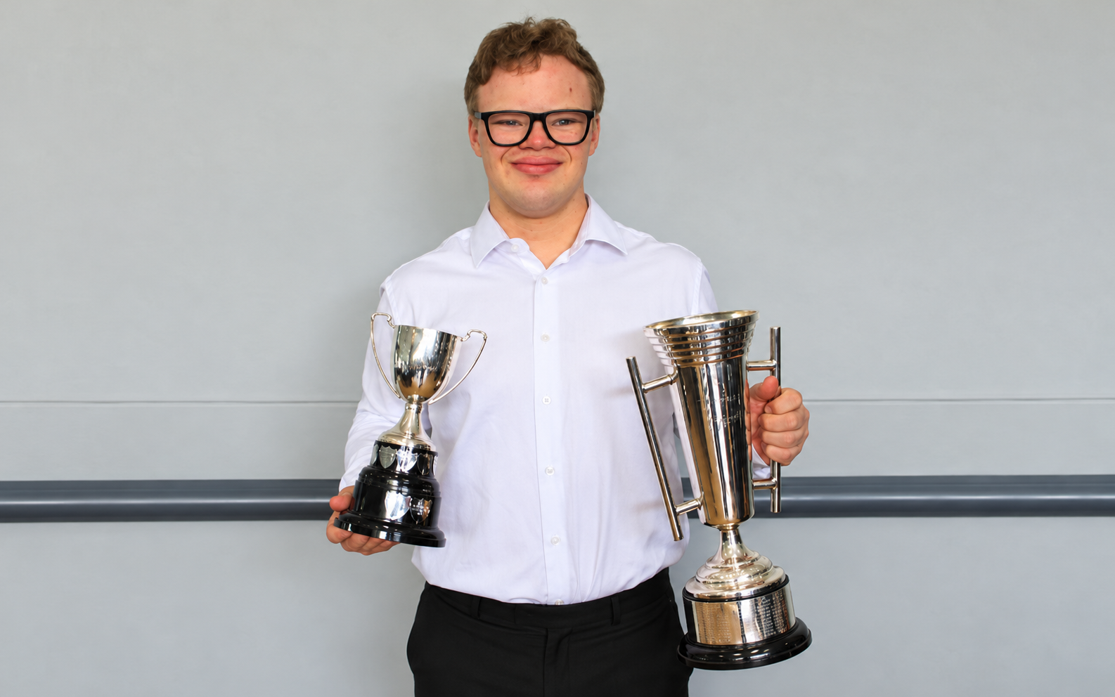 Lorenzo Cazzavillan holding two swimming trophies